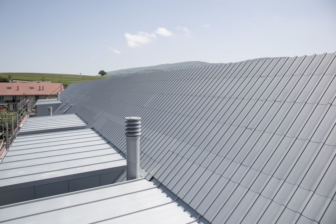 Grossflächiges Metalldach aus Titanzink mit Stehfalzdeckung auf Gebäude in ländlicher Umgebung, Schweiz, Aargau