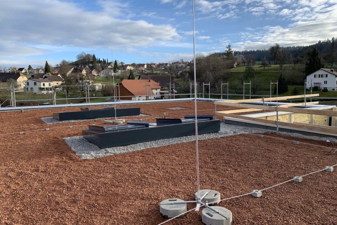 Blitzschutzanlage mit Erdung auf Flachdach mit Kiesbelag in ländlicher Umgebung im Aargau, Schweiz